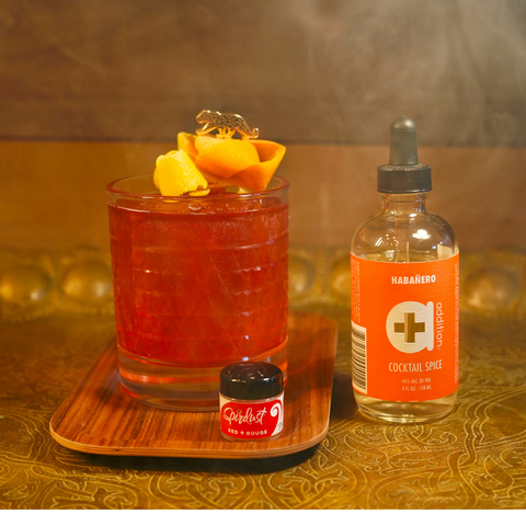 a red cocktail in a lowball glass